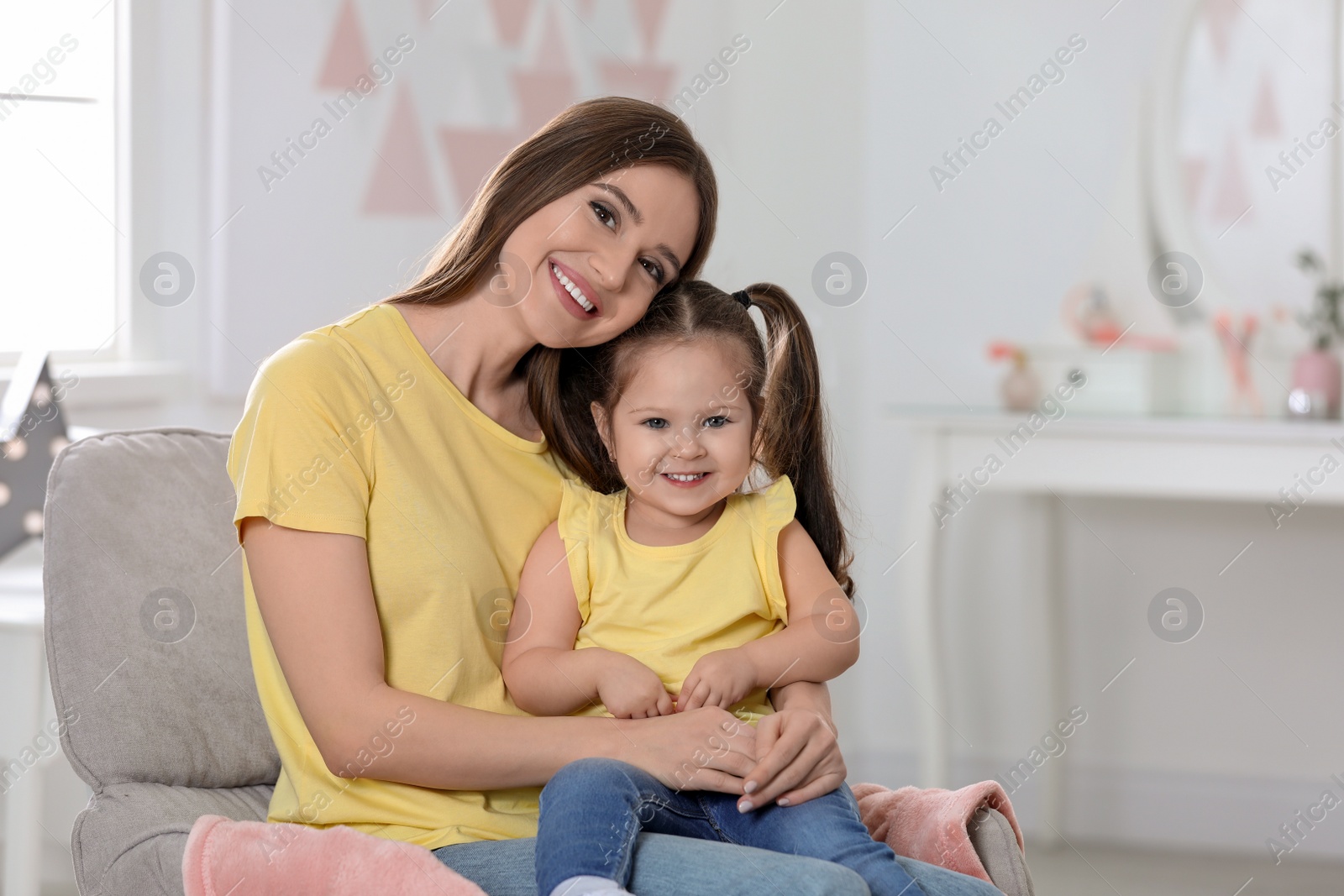 Photo of Young mother with little daughter at home