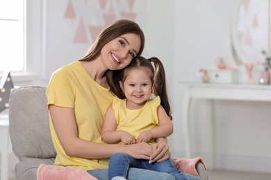 Young mother with little daughter at home