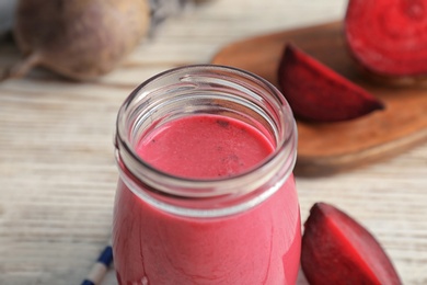 Jar with healthy detox smoothie and beet on table