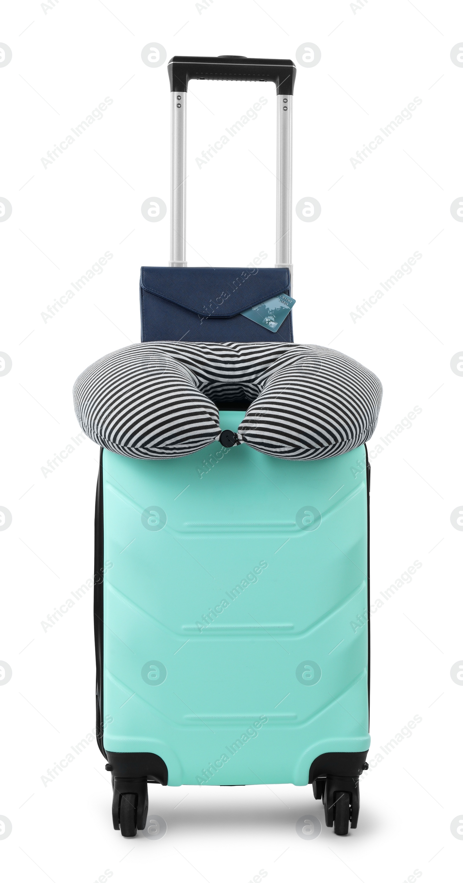 Photo of Soft travel pillow and purse on turquoise suitcase isolated on white