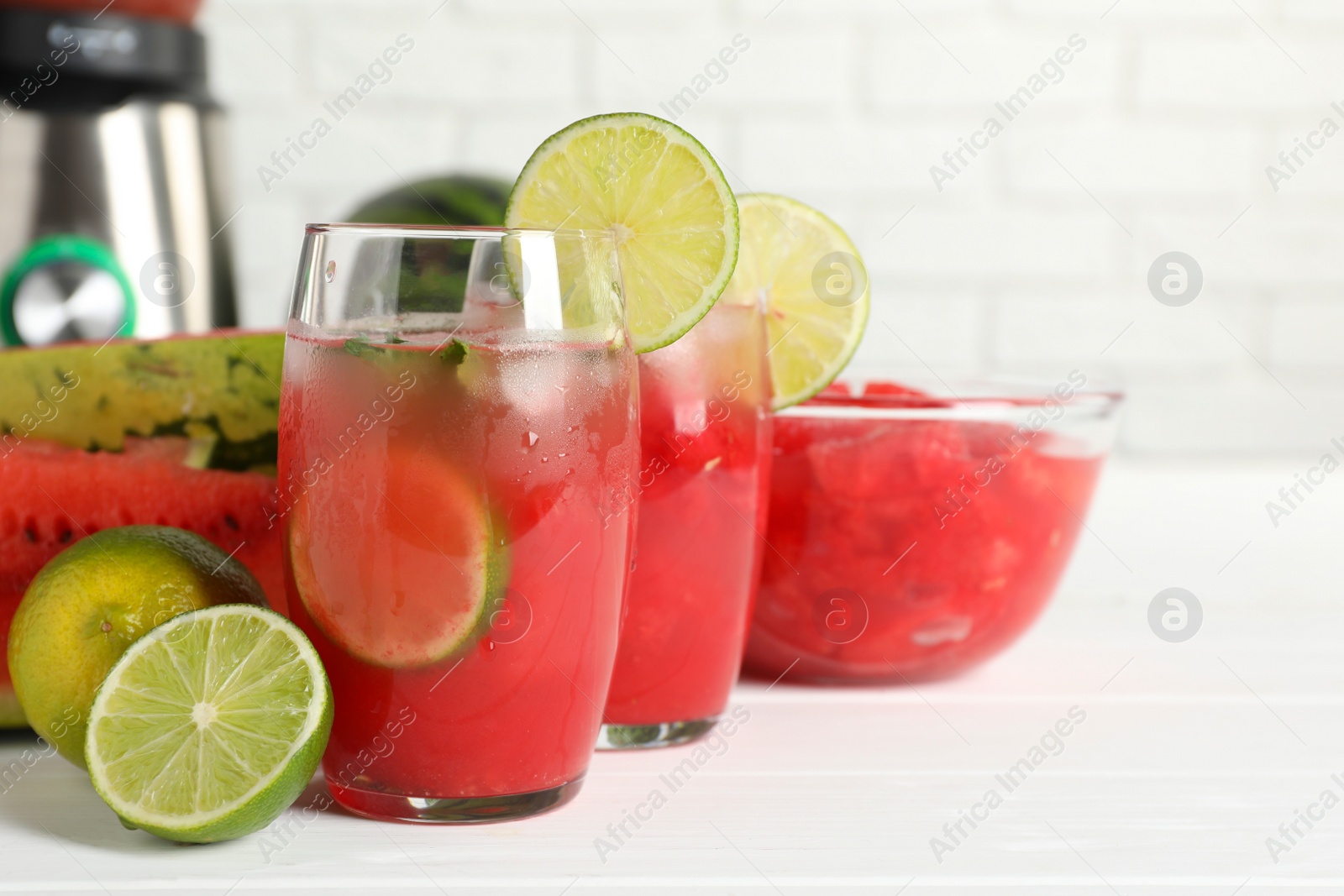 Photo of Fresh watermelon drink with lime and ingredients on white wooden table