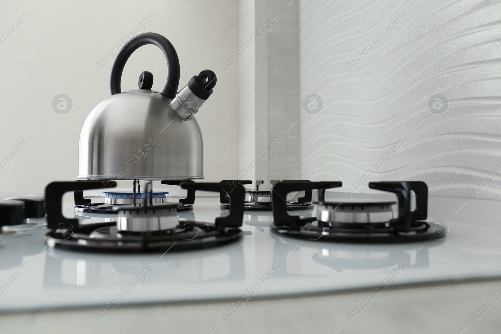 Photo of Kettle on modern gas stove in kitchen