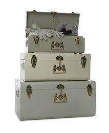 Photo of Stylish storage trunks with earmuffs and gloves on white background. Interior elements