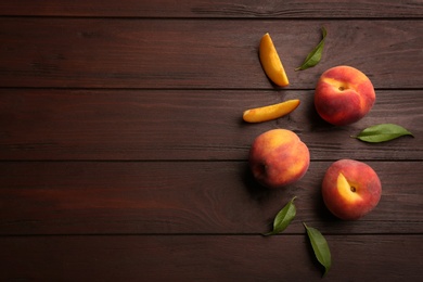 Fresh sweet peaches on wooden table, flat lay. Space for text