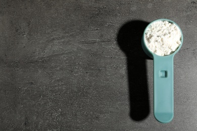 Photo of Scoop of protein powder on grey background, top view