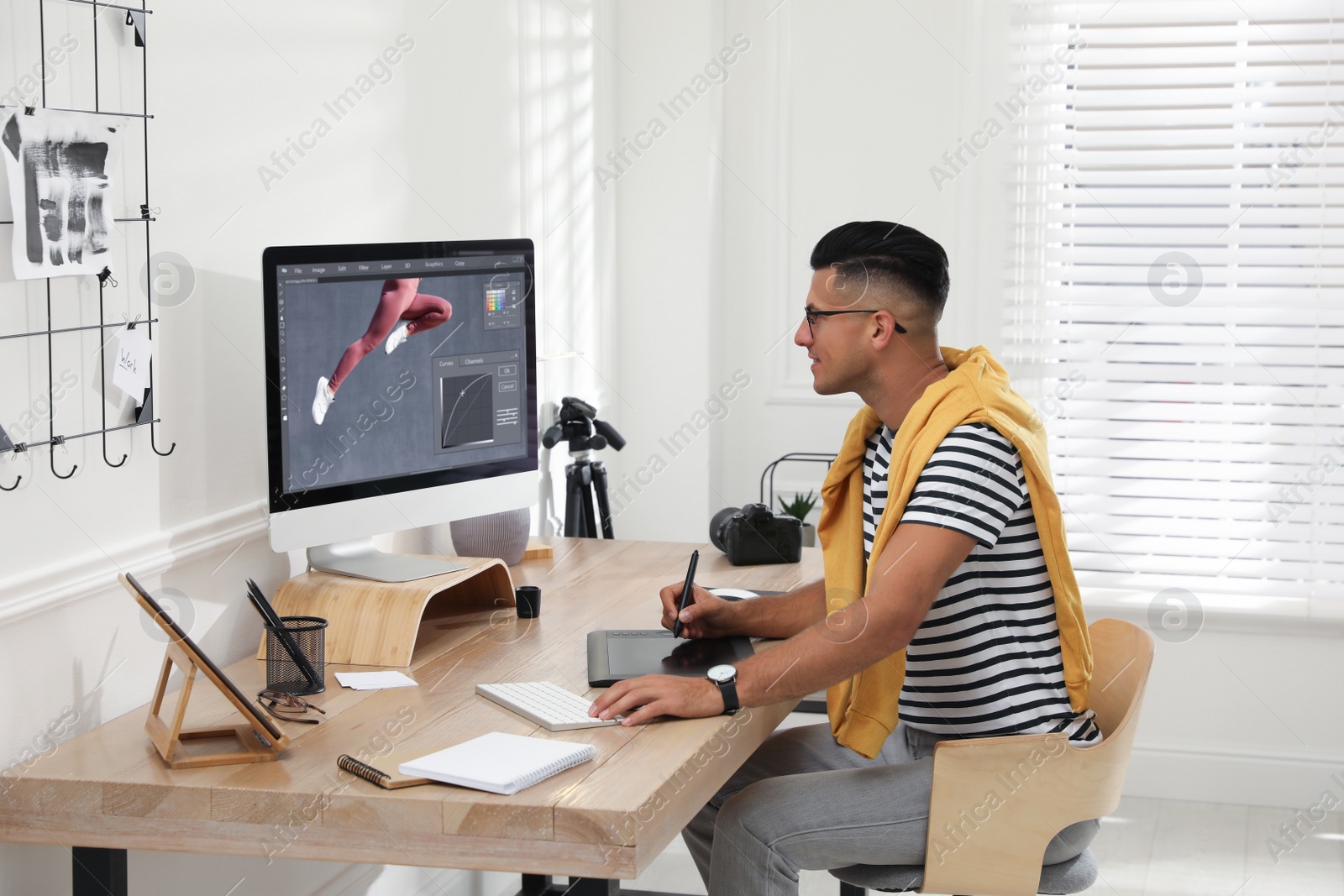 Photo of Professional retoucher working on graphic tablet at desk in office