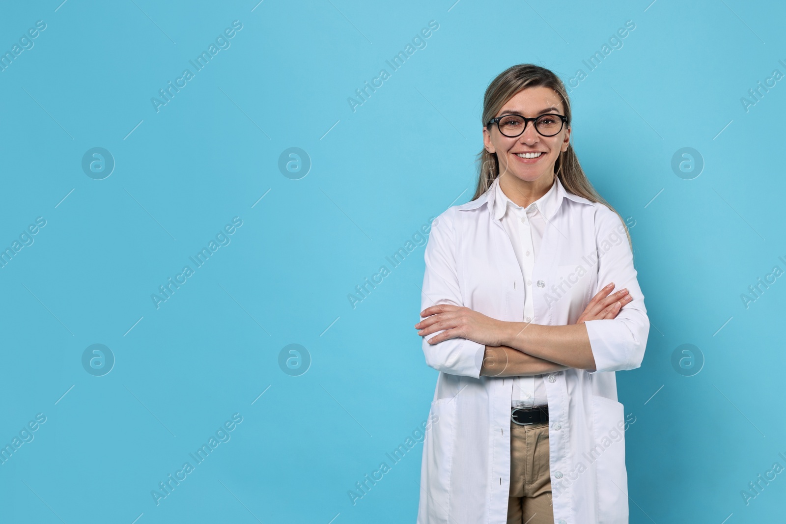 Photo of Portrait of happy doctor on light blue background, space for text