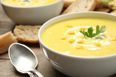 Photo of Delicious creamy corn soup served on table, closeup