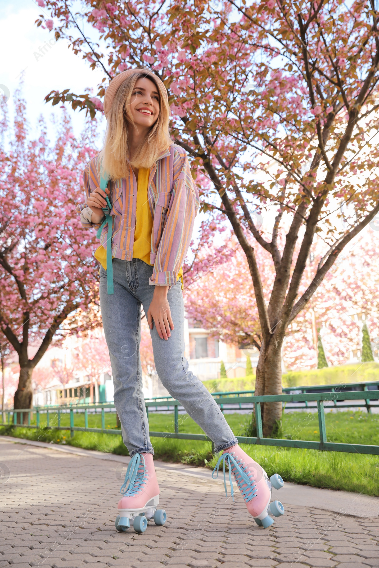 Photo of Young woman roller skating in spring park