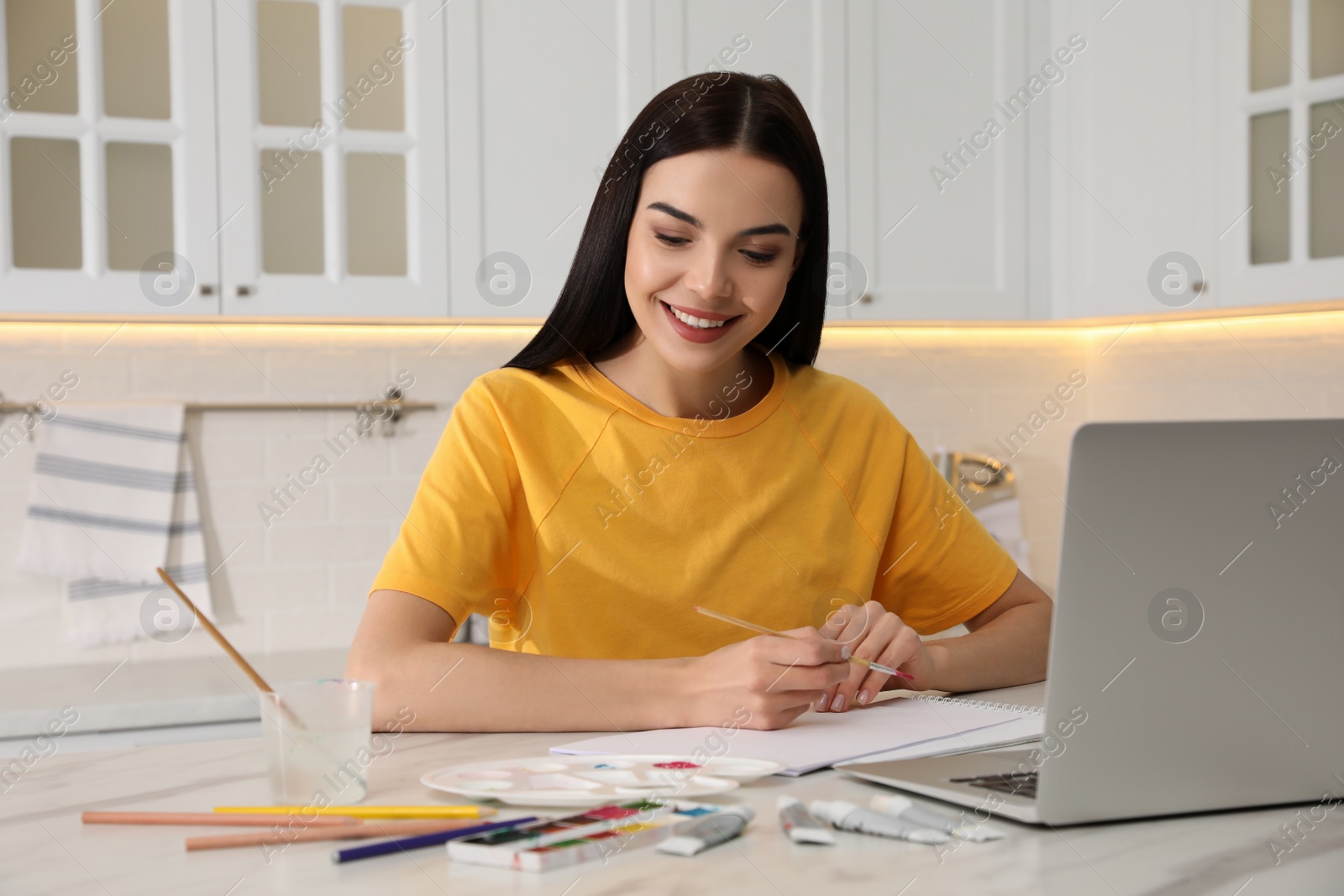 Photo of Happy woman drawing picture at online art lesson indoors. Distant learning