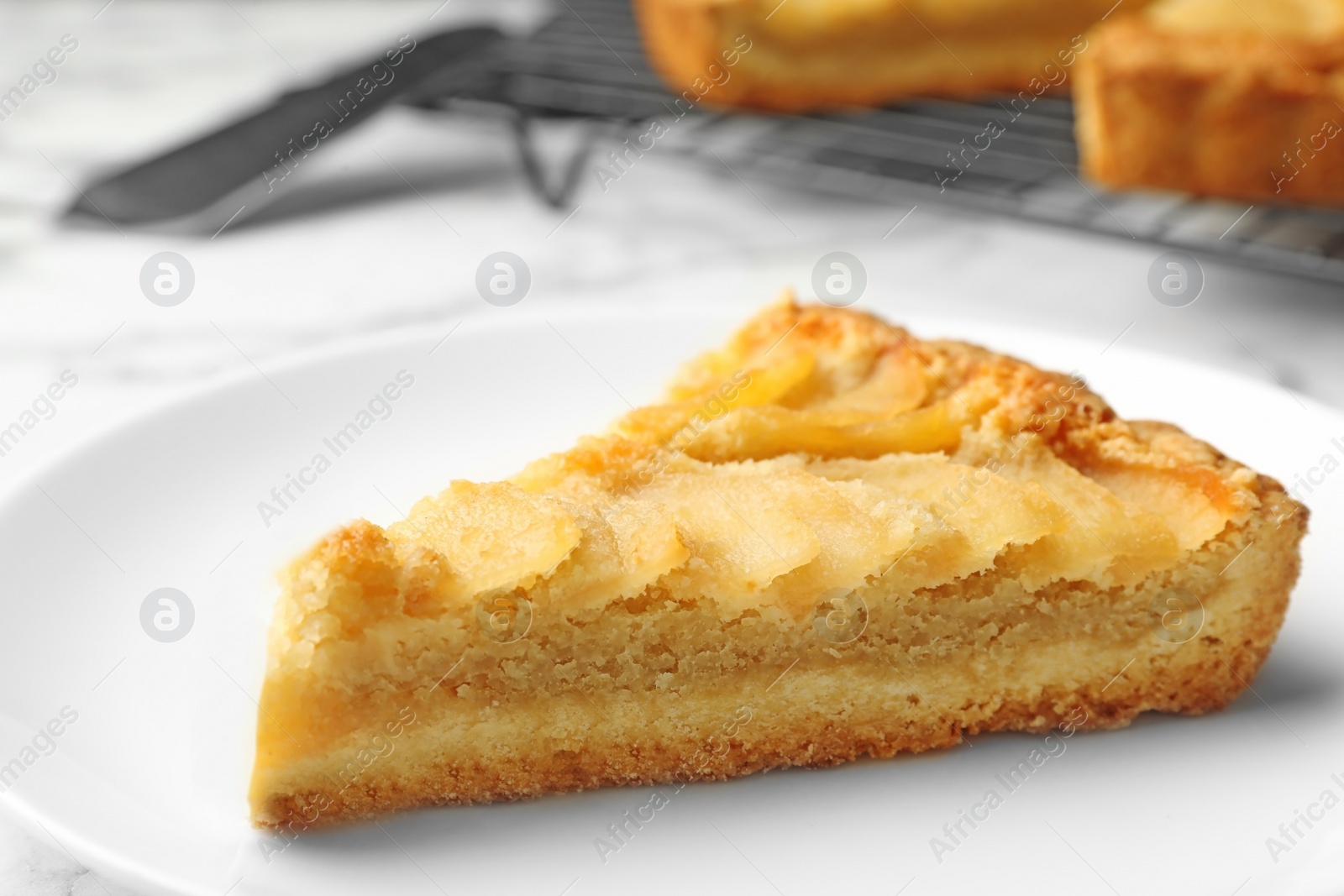 Photo of Piece of delicious sweet pear tart on table, closeup