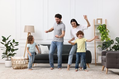 Happy family dancing and having fun in living room