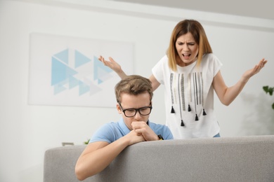 Photo of Mother scolding her teenager son at home