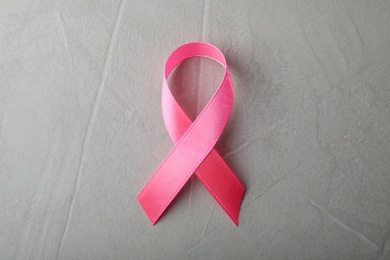 Photo of Pink ribbon on grey background, top view. Breast cancer awareness concept