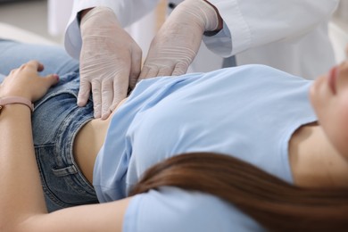 Photo of Gastroenterologist examining patient with stomach pain in clinic, closeup