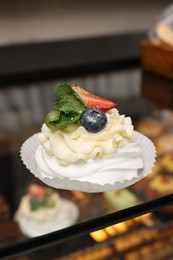 Photo of Delicious meringue dessert on counter in bakery shop, closeup. Space for text