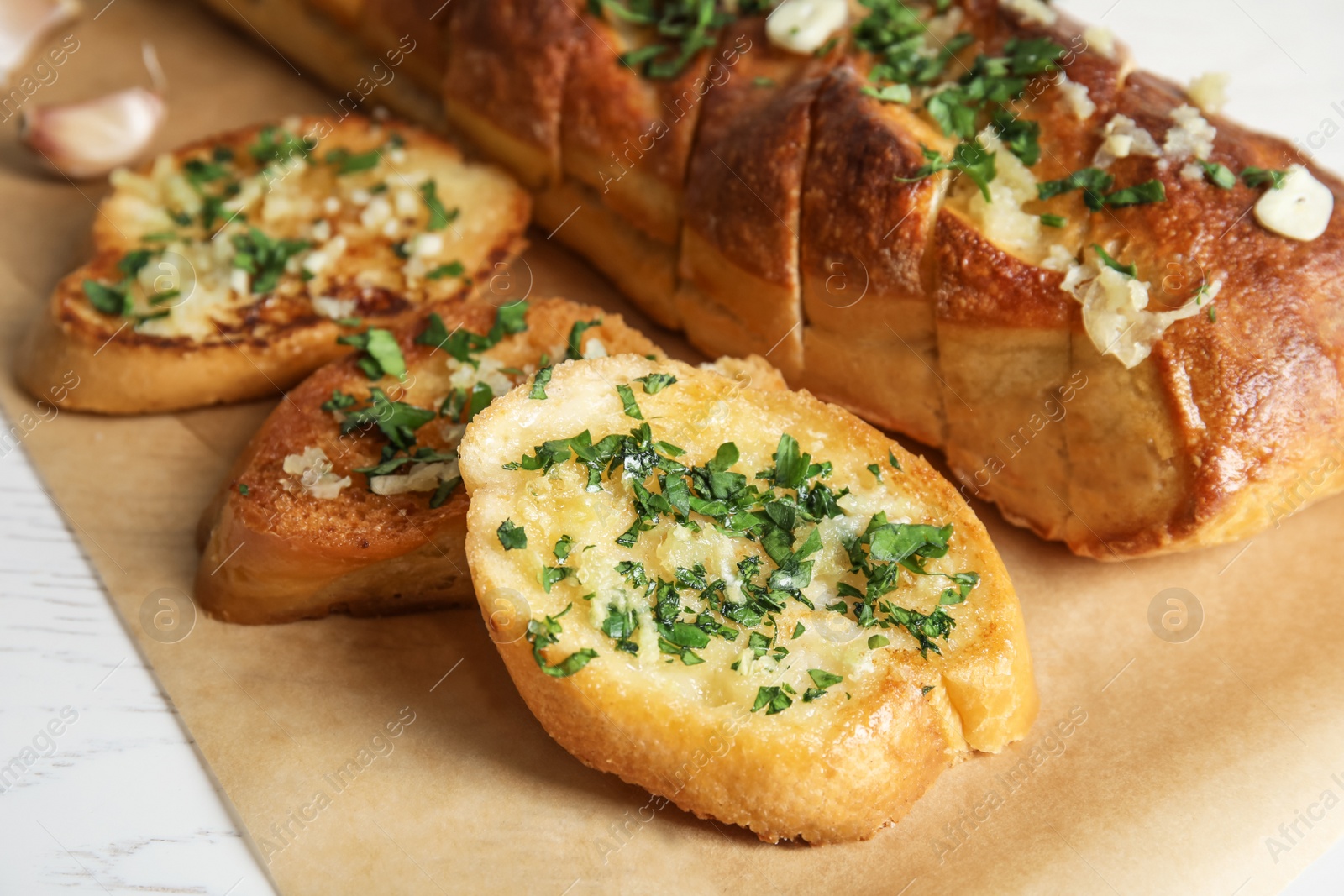 Photo of Delicious homemade garlic bread with herbs on table