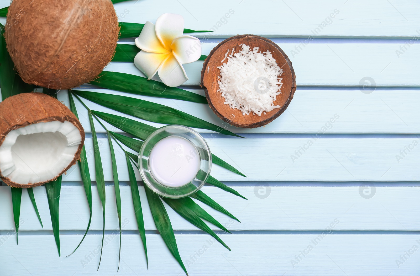 Photo of Beautiful composition with coconut oil and nuts on wooden background