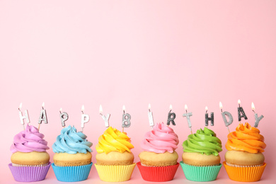 Photo of Birthday cupcakes with burning candles on pink background. Space for text