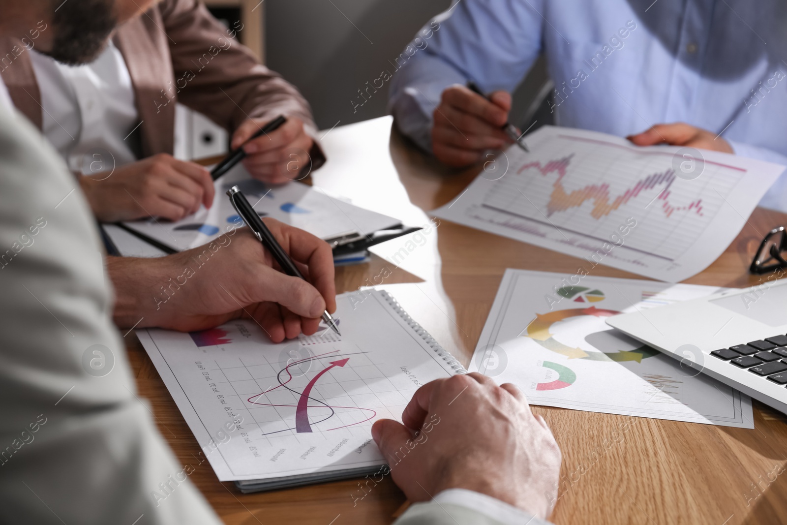 Photo of Business people working with charts and graphs at table in office, closeup. Investment analysis