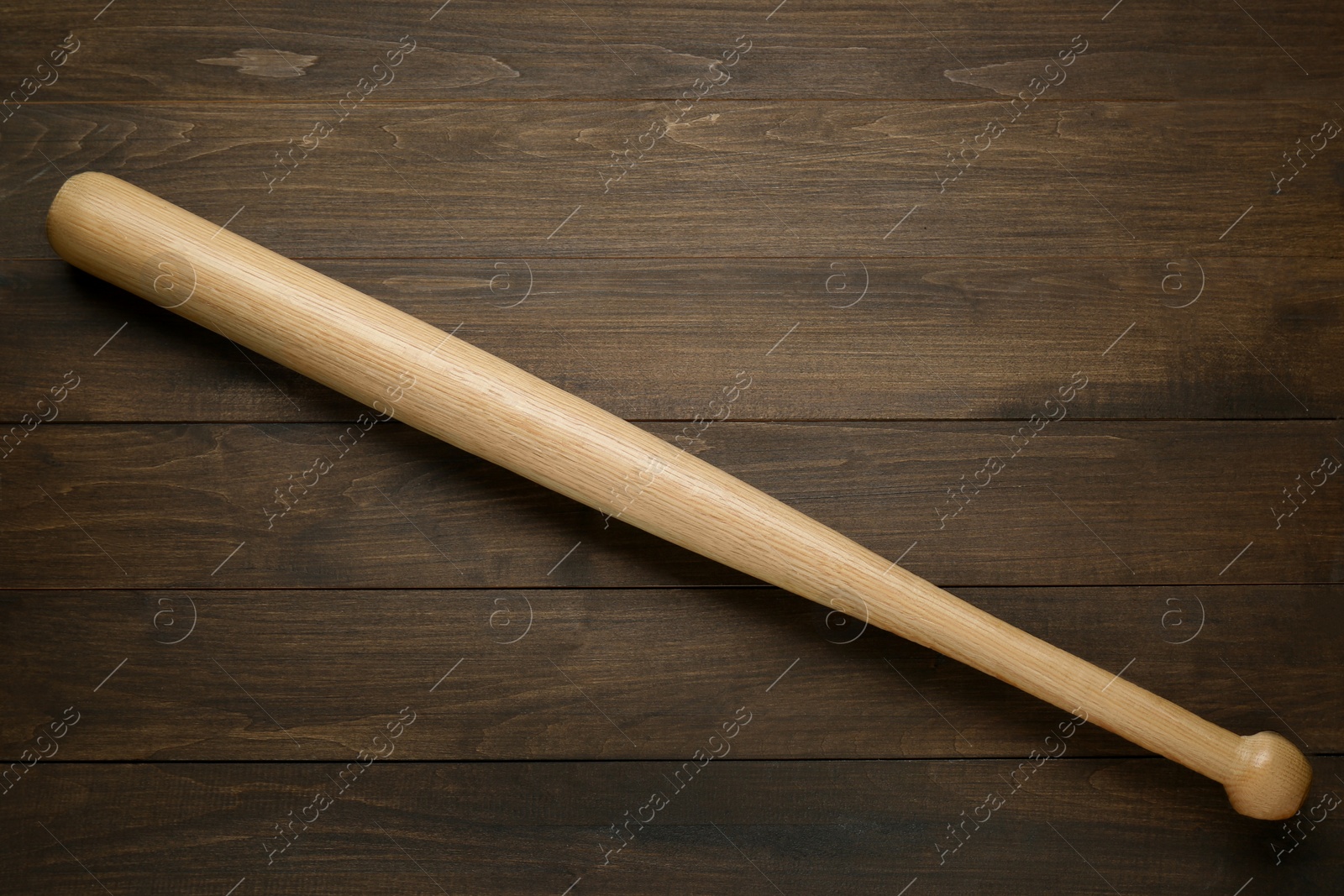 Photo of Baseball bat on wooden table, top view. Sports equipment