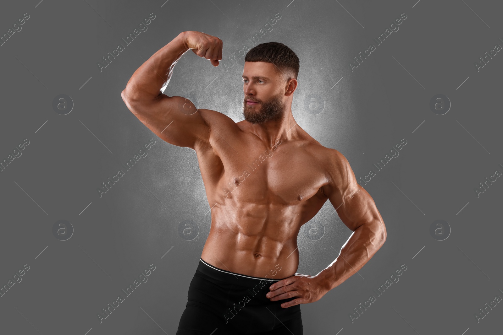 Photo of Young bodybuilder with muscular body on grey background
