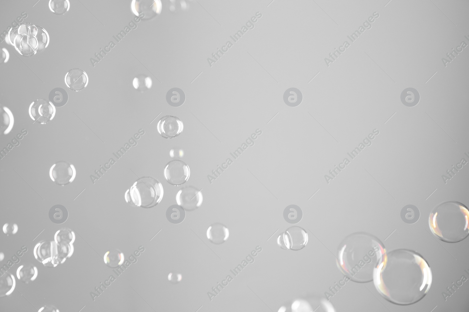 Photo of Beautiful transparent soap bubbles on grey background, space for text