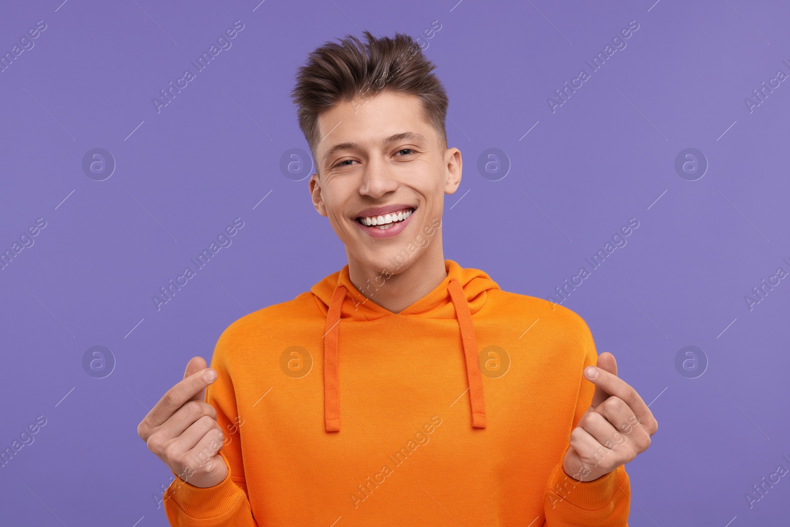 Photo of Happy man showing money gesture on purple background