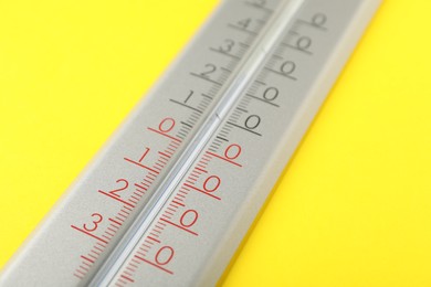 Modern weather thermometer on yellow background, closeup