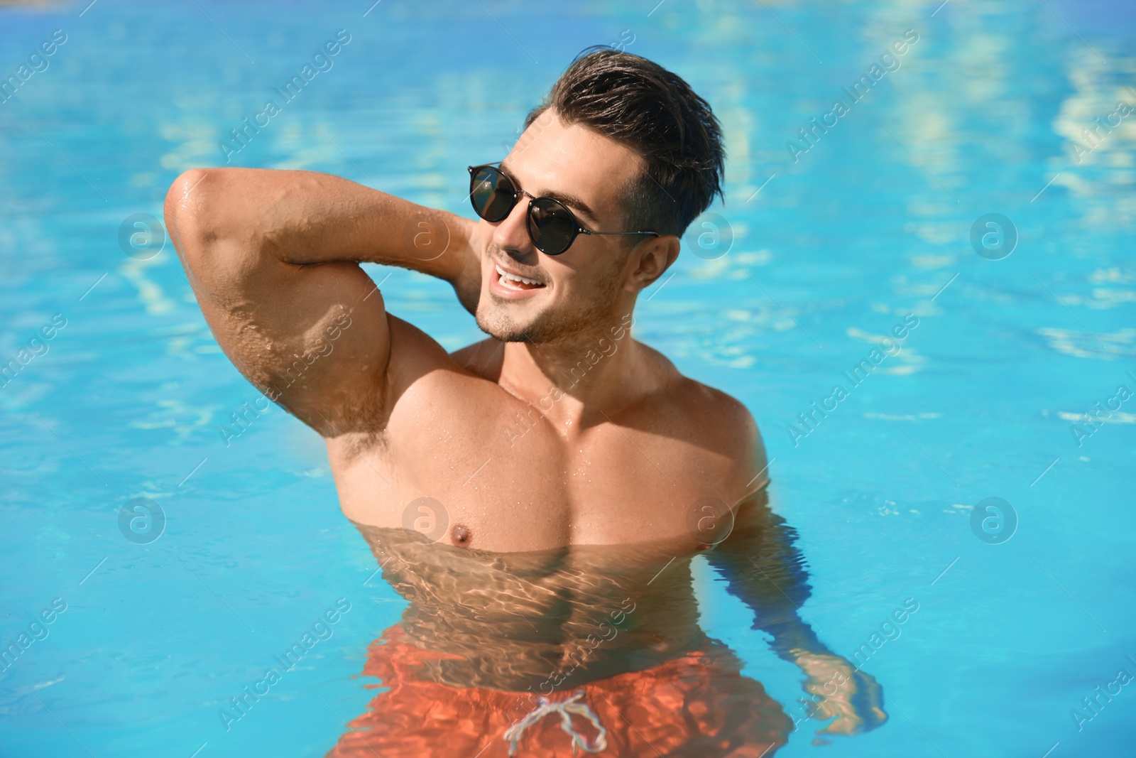 Photo of Young man in pool on sunny day
