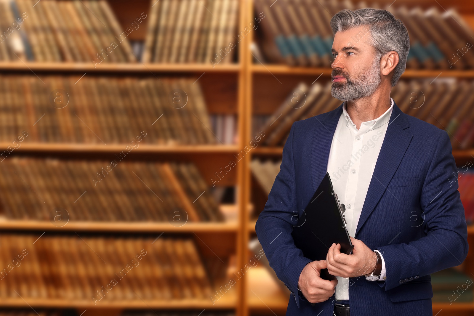 Image of Lawyer with clipboard against shelves with books, space for text