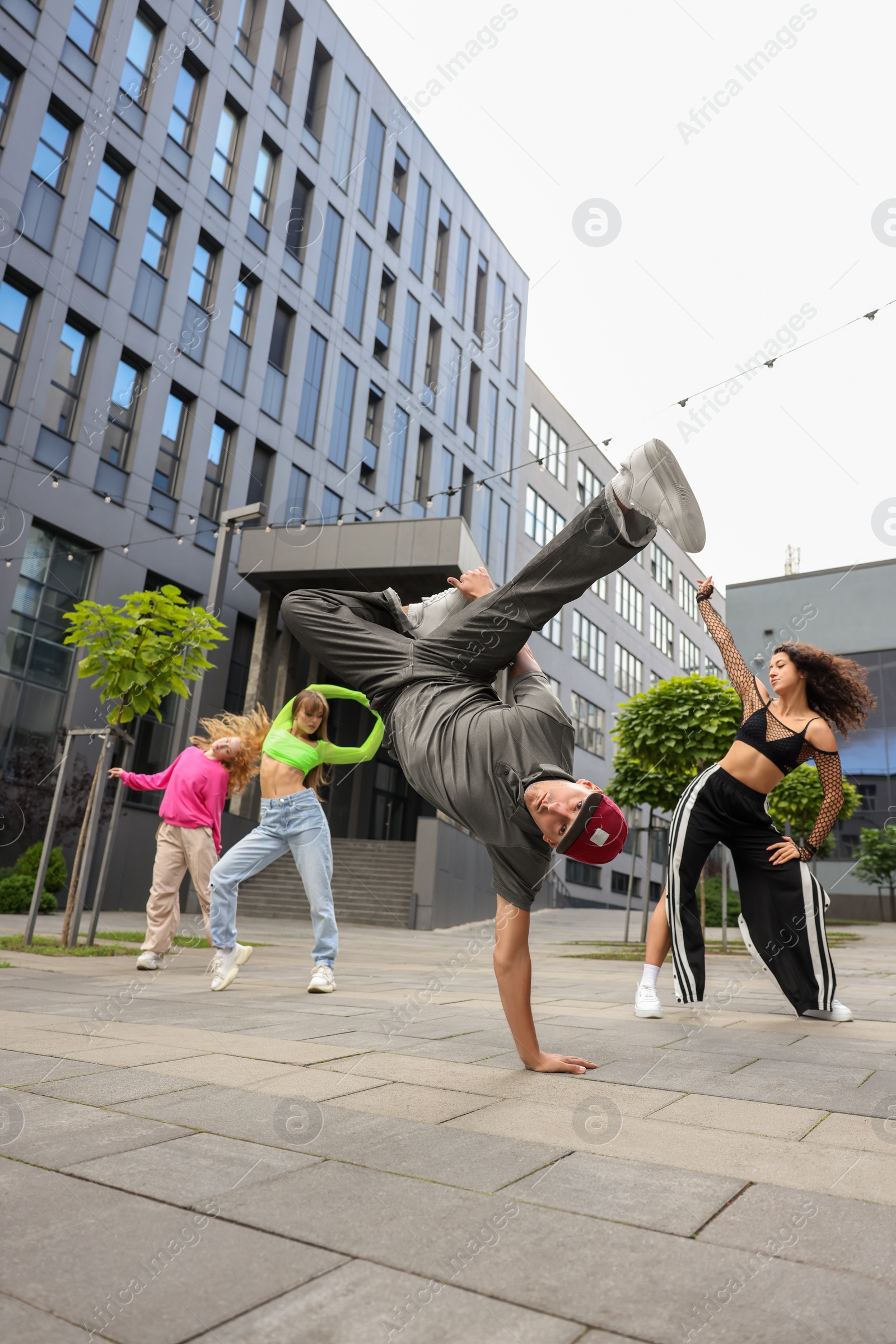 Photo of Group of people dancing hip hop outdoors, low angle view