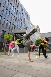 Photo of Group of people dancing hip hop outdoors, low angle view