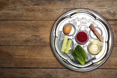Passover Seder plate (keara) on wooden table, top view with space for text. Pesah celebration