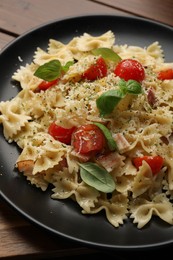 Plate of delicious pasta with tomatoes, basil and parmesan cheese on table, closeup