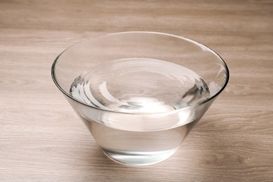 Glass bowl with water on wooden table