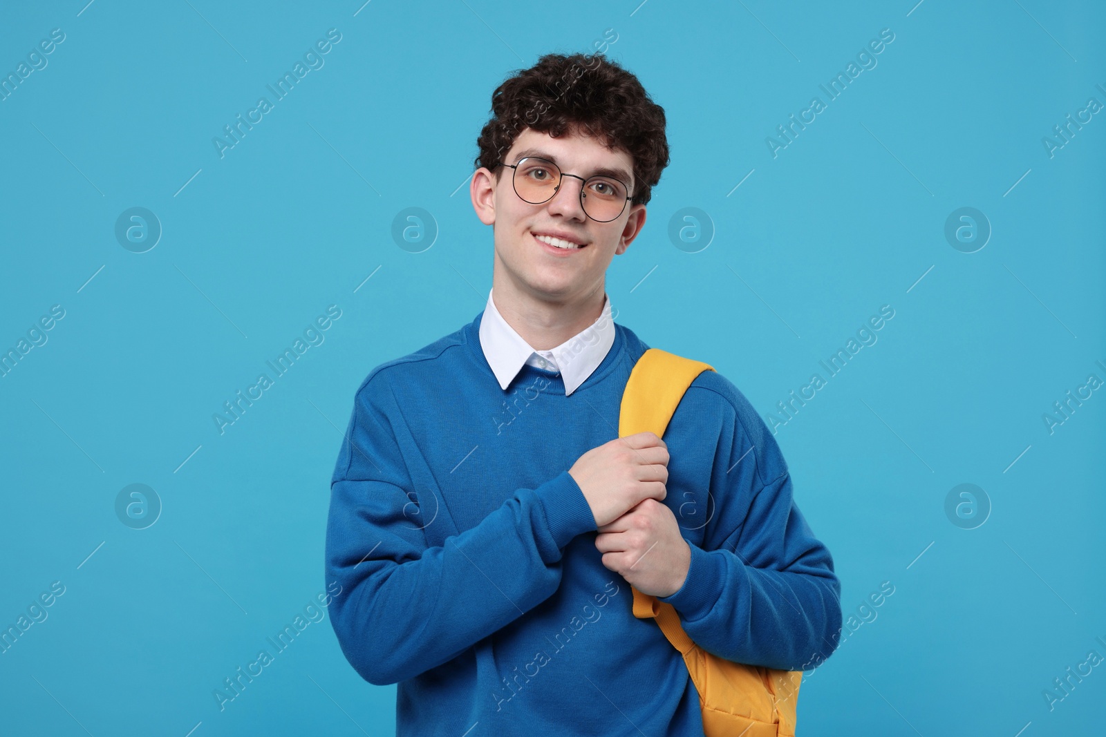 Photo of Portrait of student with backpack on light blue background