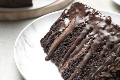 Piece of fresh delicious chocolate cake on white table, closeup