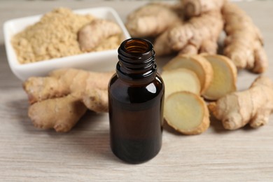 Photo of Ginger essential oil in bottle on wooden table
