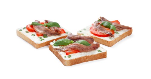 Photo of Delicious sandwiches with cream cheese, anchovies, tomatoes and basil on white background