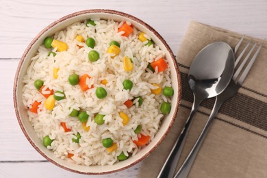 Photo of Bowl of delicious rice with vegetables served on white wooden table, flat lay