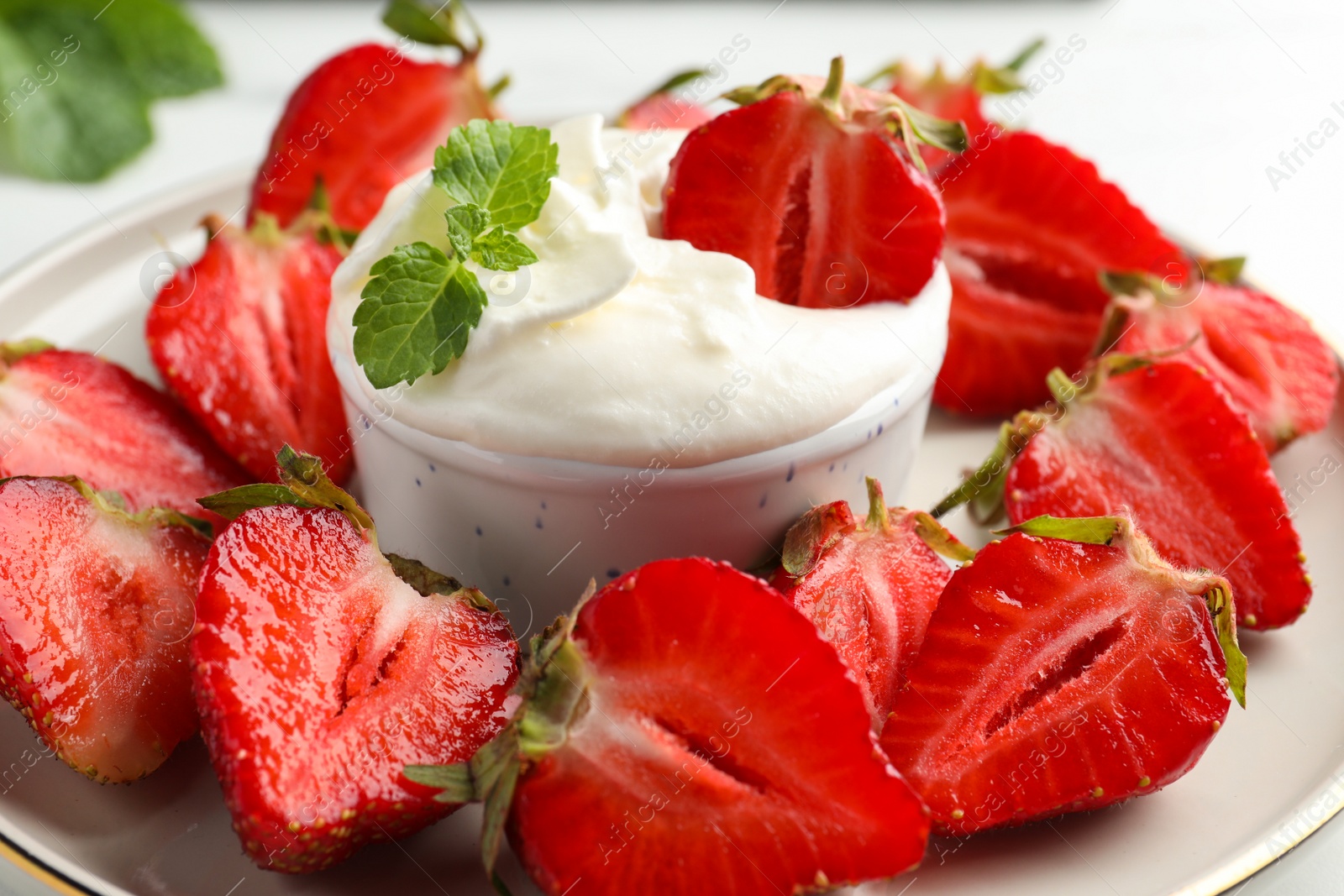 Photo of Delicious strawberries with whipped cream on plate, closeup