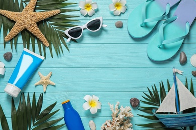 Flat lay composition with stylish beach accessories on light blue wooden background, space for text