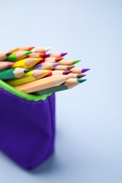 Photo of Many colorful pencils in pencil case on light grey background
