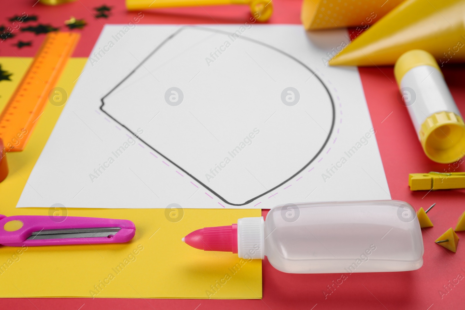 Photo of Handmade party hat template and supplies on red background, closeup