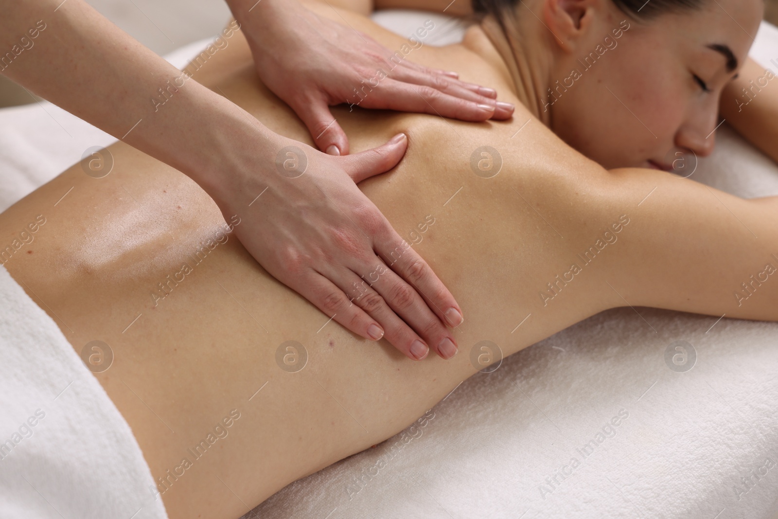 Photo of Woman receiving back massage on couch in spa salon, closeup