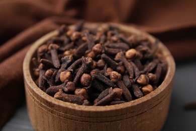 Photo of Aromatic cloves in bowl on table, closeup