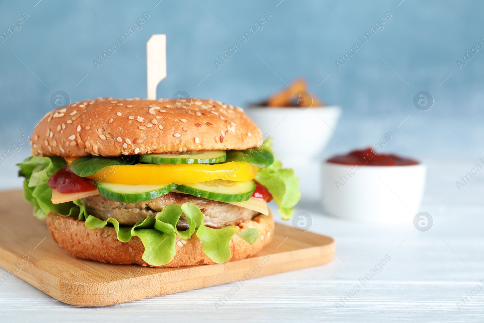 Photo of Board with delicious hamburger on table. Space for text