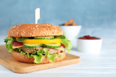 Photo of Board with delicious hamburger on table. Space for text