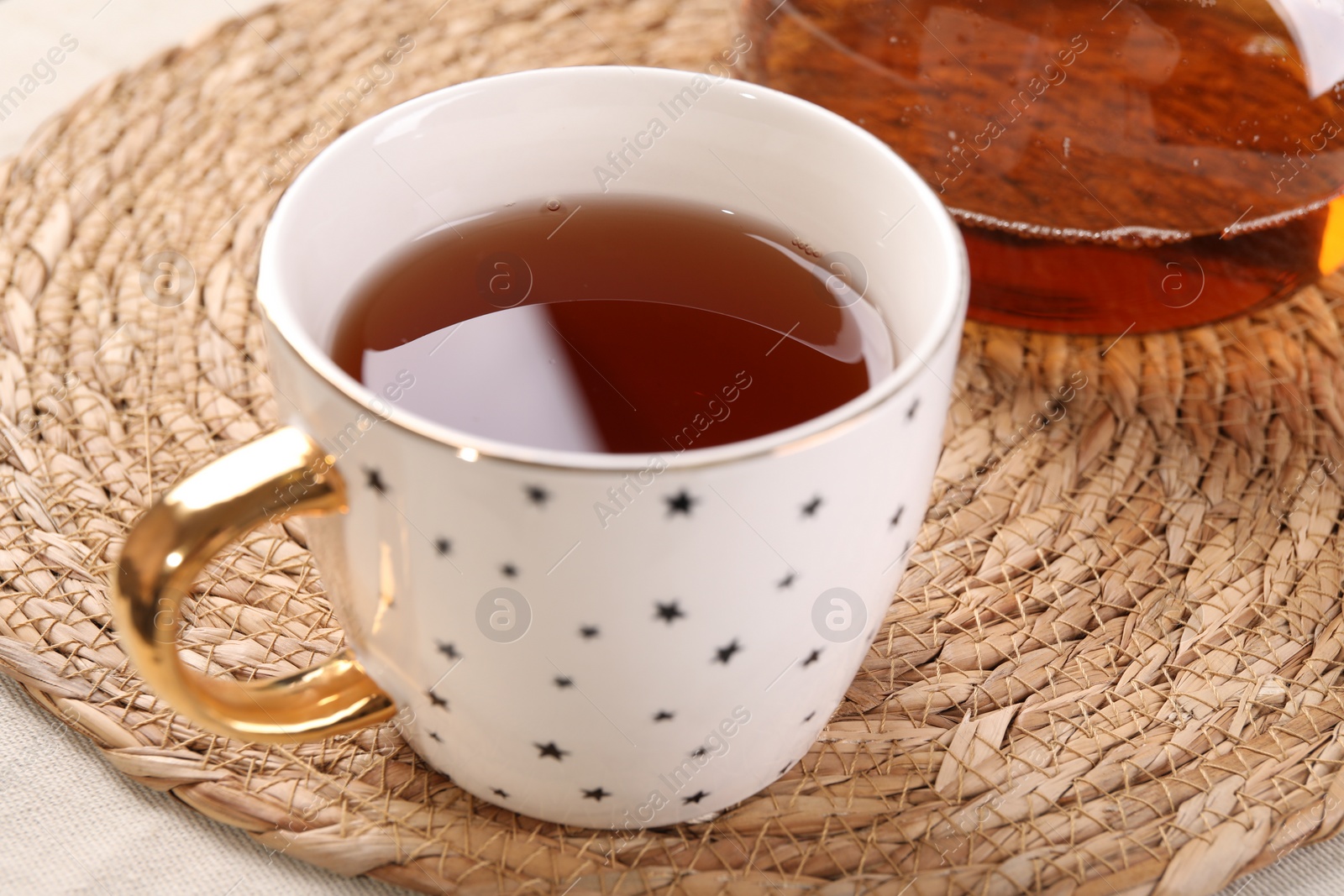 Photo of Aromatic tea in cup on table, closeup